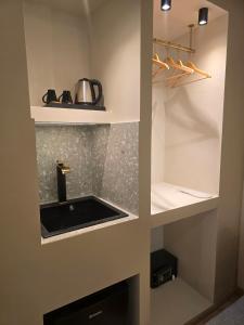a kitchen with a sink and a shelf at Hotel Nefeli in Volos +85 photos