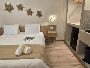 a hotel room with two beds and a book at Hotel Nefeli in Volos