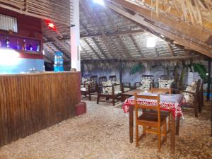 a restaurant with a table and chairs and a bar at Hotel Le Petit Paradis in Antsiranana