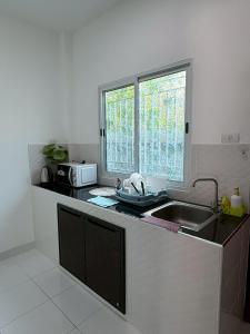 a kitchen with a sink and a window at AN Airport Guesthouse in Nai Yang Beach