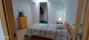 a bedroom with a bed and a dresser and a mirror at Habitaciones turísticas copitos in Gandía +7 photos