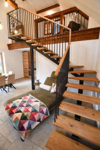 a living room with a spiral staircase with a couch at Wohlfühl Apartments am Hof Rapotz in Leutschach