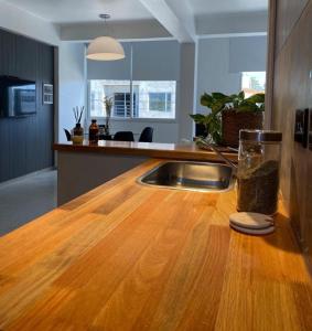 a kitchen with a wooden counter top and a sink at NuMa MAR in Puerto Madryn