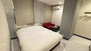 a bedroom with a white bed and a red chair at ホテルパルシス大人専用 in Shiroishi +9 photos