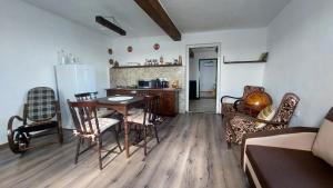 a living room with a table and chairs and a kitchen at Konyhadűlő Vendégház in Kiskunmajsa