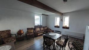 a living room with a couch and a table and chairs at Konyhadűlő Vendégház in Kiskunmajsa +23 photos