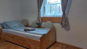 a small bedroom with a bed with a window at Konyhadűlő Vendégház in Kiskunmajsa