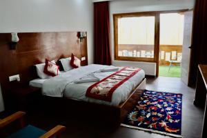 a bedroom with a large bed and a window at The Kun in Leh