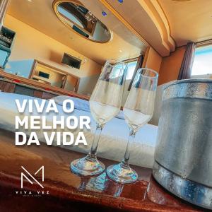 two wine glasses sitting on a table with a bucket at Motel Viva Vez in Canoas