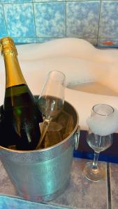 a bottle of champagne in an ice bucket next to a glass at Motel Viva Vez in Canoas