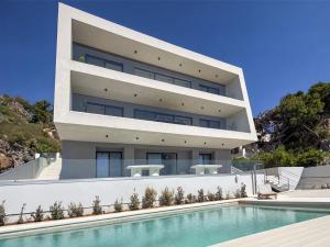 a building with a swimming pool in front of it at Villa Erifyli in Aghia Marina