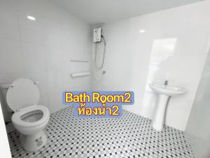 a bathroom with a toilet and a sink at Whitebeach Cottage in Chon Buri