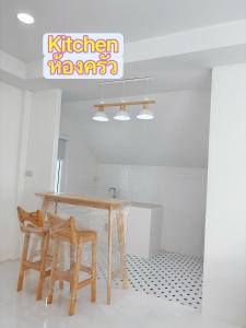 a table and two chairs in a room at Whitebeach Cottage in Chon Buri