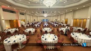 a large banquet hall with white tables and chairs at Torres de Manantiales Apart Hotel in Mar del Plata