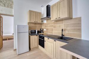 a kitchen with wooden cabinets and a white refrigerator at Studio 2p rénové - Centre 5min- Stationnement in Angoulême