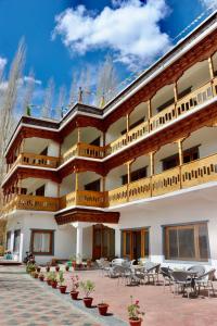 a large building with tables and chairs on a patio at The Kun in Leh