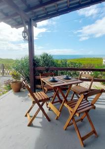 a wooden picnic table and chairs on a patio at Pousada Atlantik-Haus in Costa Dourada