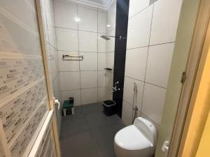 a small bathroom with a toilet and a shower at Nirmala Grand in Rāmeswaram