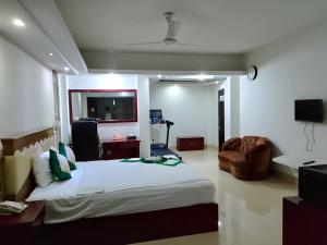 a bedroom with a large bed and a living room at Hotel Crown in Rājshāhi