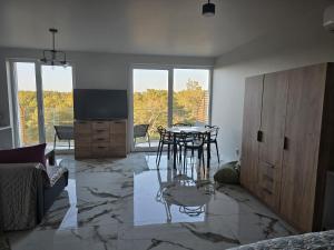 a living room with a table and some chairs at Apartament Sosnowy Las Widok na morze in Rowy