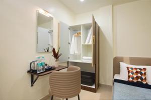 a bedroom with a mirror and a chair and a bed at Greens Venue in Chennai +34 photos