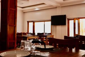 a dining room with tables and chairs and a television at The Kun in Leh