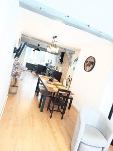 a dining room and living room with a table and chairs at Le flocmagny in Chalons en Champagne