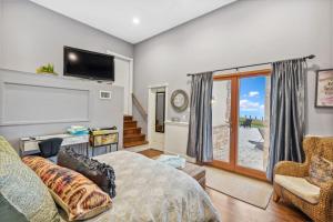 a living room with a bed and a tv at Hamptons Romantic Waterfront Queen Suite in Remsenburg