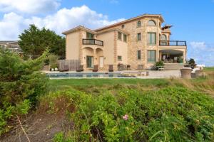 a large stone house with a pool in front of it at Hamptons Romantic Waterfront Queen Suite in Remsenburg