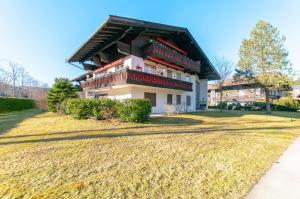 a large house with a gambrel roof on a yard at Ferienwohnung Steinfeldstrasse am Tegernsee in Rottach-Egern