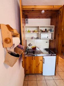 a small kitchen with a sink and a refrigerator at Edelweiss Pila-Ski appartment con vista montagne in Pila