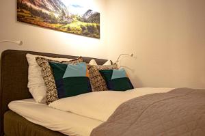 a bed with pillows on it in a room at Ferienwohnung Steinfeldstrasse am Tegernsee in Rottach-Egern
