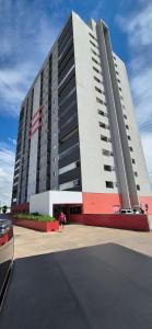 a large building with a person standing in front of it at Flat 203 Red Sorocaba in Sorocaba