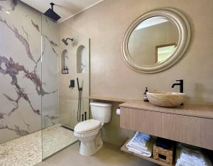 a bathroom with a toilet and a sink and a mirror at NEW RENOVATION - Beachside Two-Bedroom Suite in Savaneta +46 photos