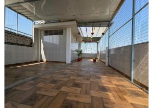 a large room with a wooden floor and windows at SHREE RAMA Niwasam in Ayodhya