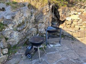 Ein Grill und ein Grillrost stehen neben einer Felswand. in der Unterkunft Birchihaus in Beatenberg