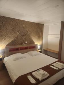a bedroom with a large bed with towels on it at Le Cocon Du Lac in Nantua