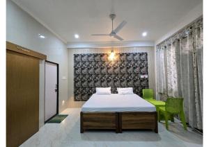a bedroom with a bed and a green chair at SHREE RAMA Niwasam in Ayodhya