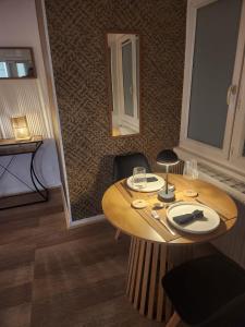 a wooden table with wine glasses on top of it at Le Cocon Du Lac in Nantua
