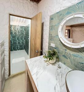 a bathroom with a sink and a mirror and a shower at Boutique Playa DanRay in La Perdiz