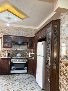 a kitchen with a stove and a refrigerator at الوليد للشقق المفروشة in Amman