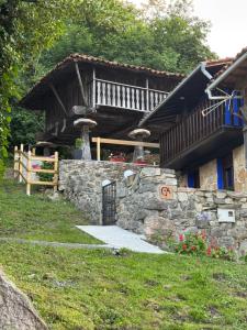 a house with a stone wall and a balcony at La Casina del Trasgu in Cangas de Onís