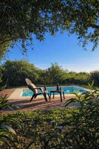 a chair and a table next to a pool at Casa Atardecer San Javier in San Javier