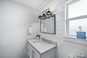 a white bathroom with a sink and a mirror at Chulavista Cozy Close to beach in Galveston +56 photos