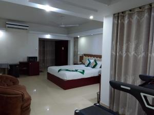 a hotel room with a bed and a couch at Hotel Crown in Rājshāhi +9 photos