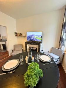 a living room with a table and a television at T2 Amboise avec vue sur le Château Royal in Amboise