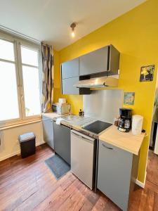 a kitchen with white appliances and a yellow wall at T2 Amboise avec vue sur le Château Royal in Amboise