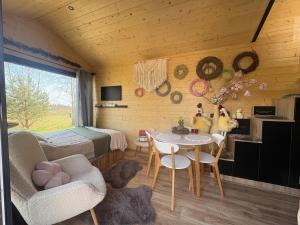 a bedroom with a bed and a table and chairs at ToTu Tiny House Sauna & wanna ogrodowa in Dobiesz