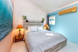a bedroom with a large bed and a painting on the wall at Beachfront Two-Bedroom Villa in Savaneta