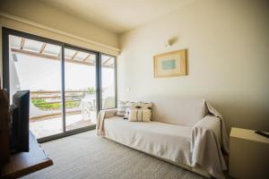 a living room with a couch and a sliding glass door at The Salty Lodge in Lagos